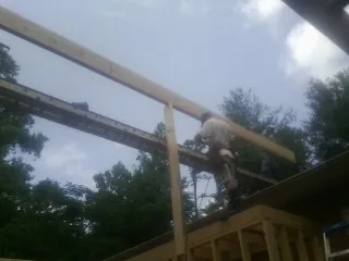 Carpenter setting a ridge beam over a new addition frame — Ice Dam Removal by Roofing Brothers in South Jamesport