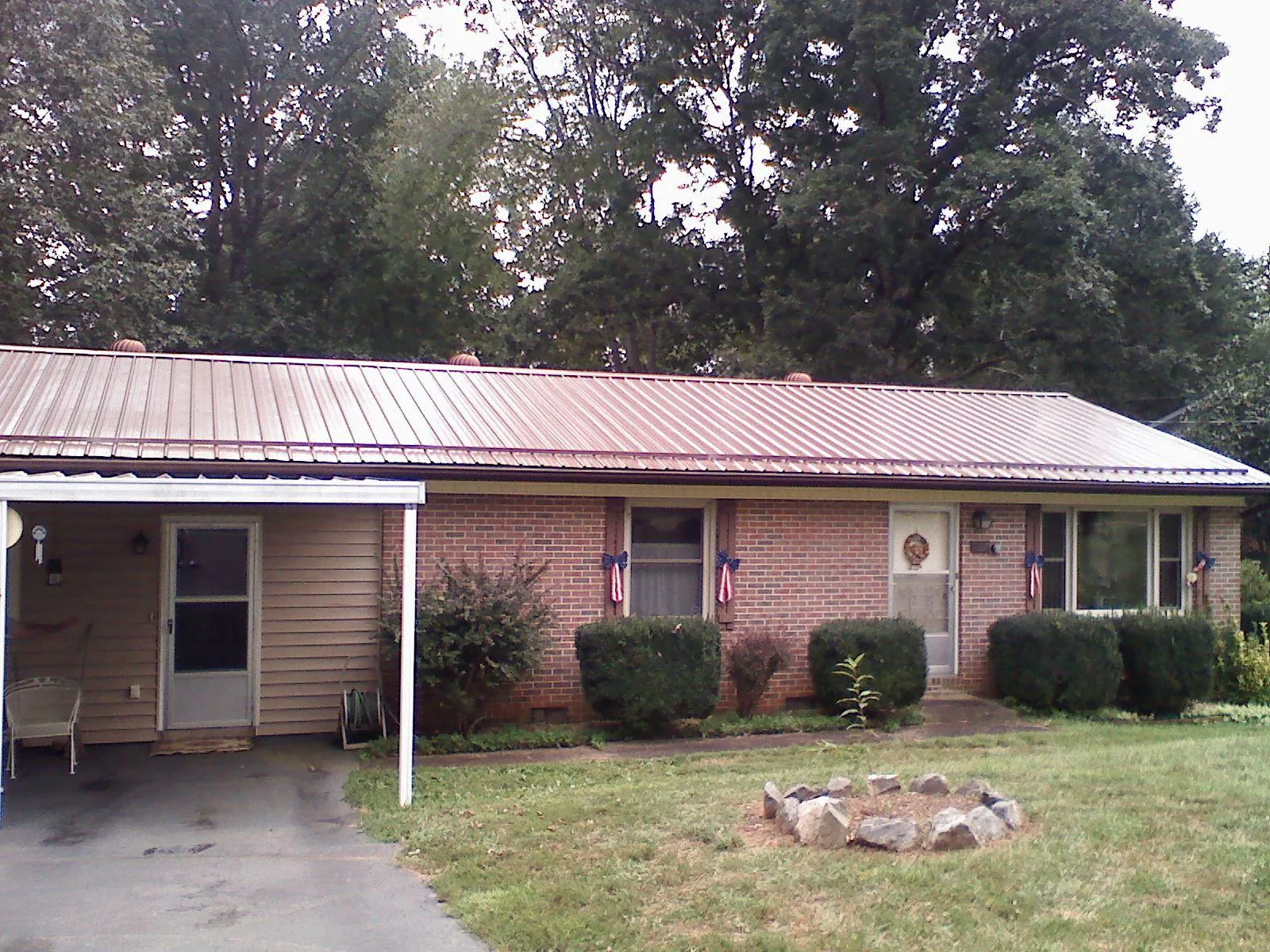 Bronze metal roof and carport on a brick ranch home — Roof Repair work by our crew in South Jamesport